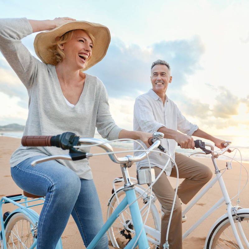 couple riding bikes on beach